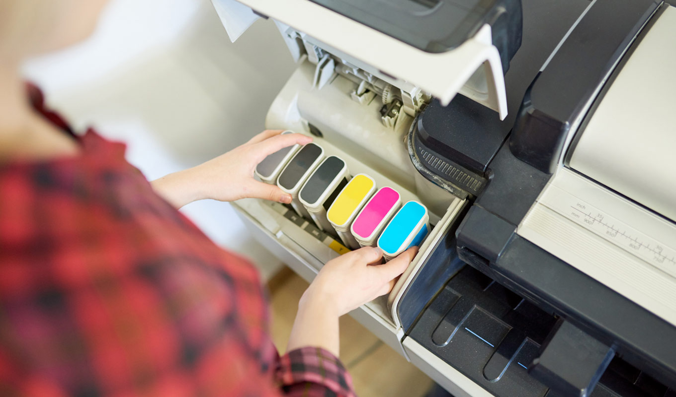 CMYK cartridges in a printer are shown. 